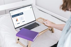 A woman looks at a budget document on her laptop.